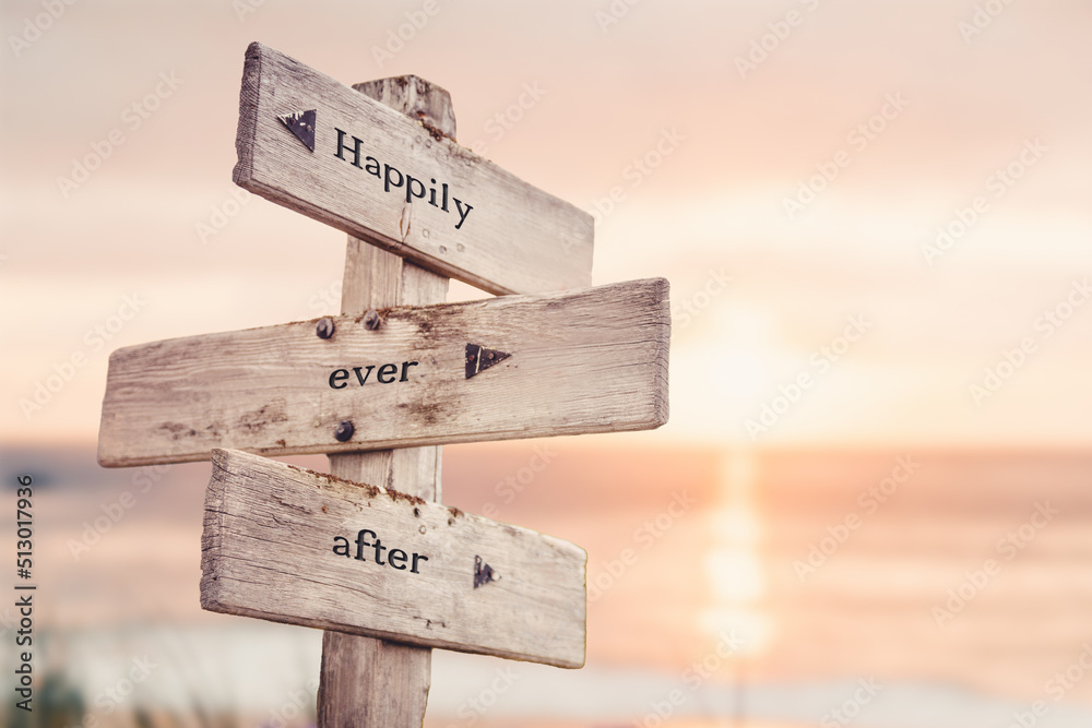 happily ever after text quote on wooden crossroad signpost outdoors on beach with pink pastel sunset colors. Romantic theme. - obrazy, fototapety, plakaty 