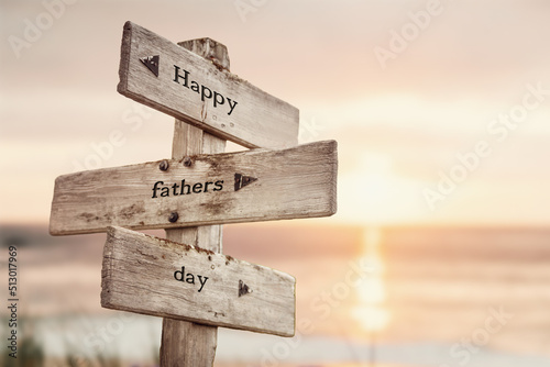 happy fathers day text quote on wooden crossroad signpost outdoors on beach with pink pastel sunset colors. Romantic theme.