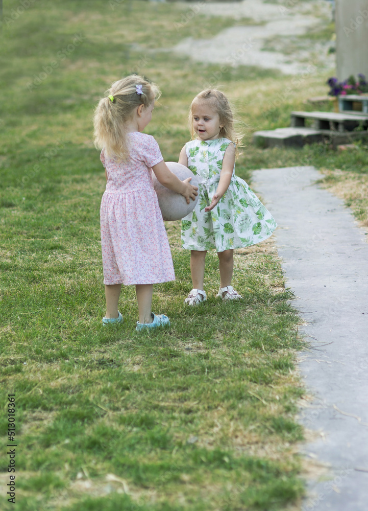 Two girls play in the yard of the house Two girls play in the yard of the house