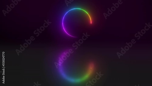 Illuminated rainbow neon lights in a circle shape or pattern against a dark background in studio. CGI circular art isolated on a black background. Special effects reflected in a mirror image