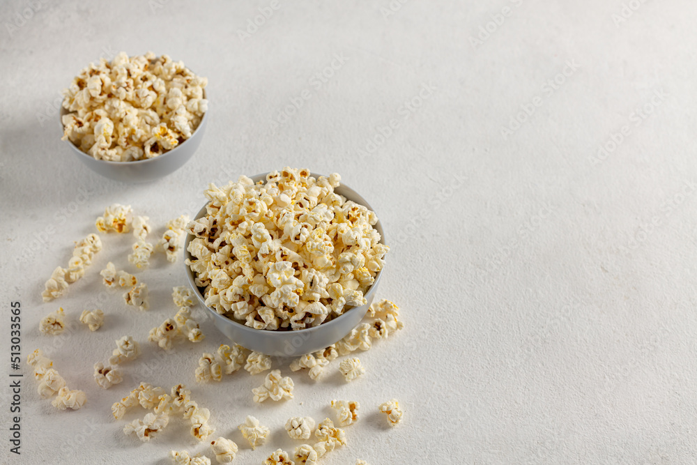 A bowl of delicious popcorn on a light background A bowl of delicious popcorn on a light background