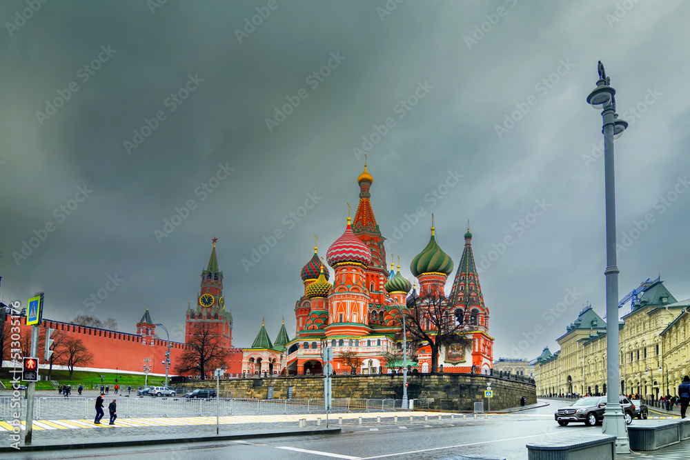 Fototapeta premium MOSCOW , RUSSIA - APRIL 26TH, 2018 : View of Moscow Red Square Kremlin towers. Moscow architecture, in a cloudy weather. It is world famous tourist spot - Saint Basil's cathedral in background.