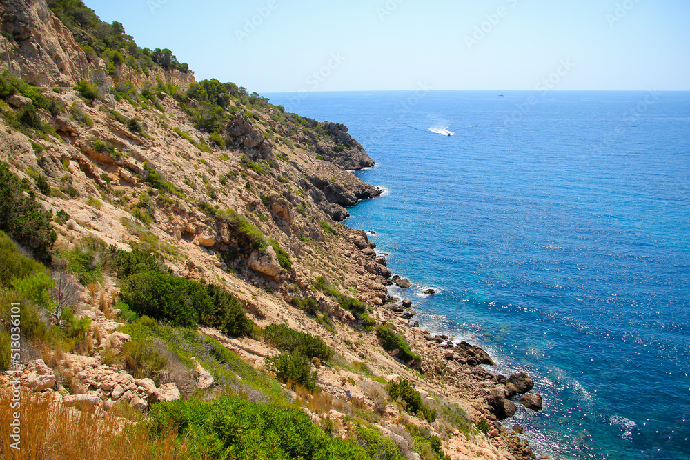 Rocky hills next to the Mediterranean Sea in the cove of Cala Llonga in the southeast of Ibiza in the Balearic Islands, Spain