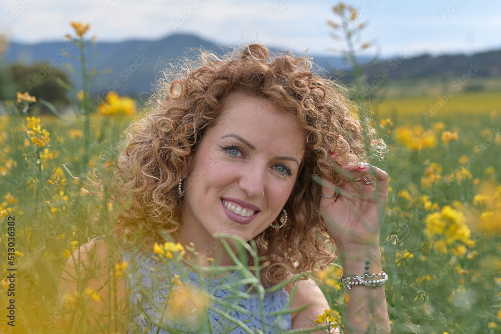 Young girl in the field, stroking her curly hair. Young girl in the field, stroking her curly hair.