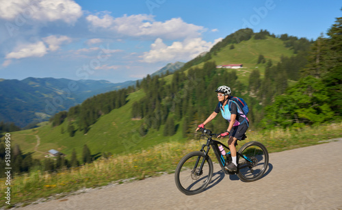 Fototapeta Naklejka Na Ścianę i Meble -  pretty senior woman riding her electric mountain bike in the Allgaeu mountains above Oberstaufen , Allgau Alps, Bavaria Germany
