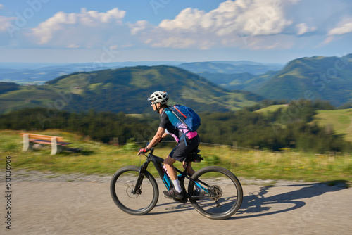 pretty senior woman riding her electric mountain bike in the Allgaeu mountains above Oberstaufen , Allgau Alps, Bavaria Germany 