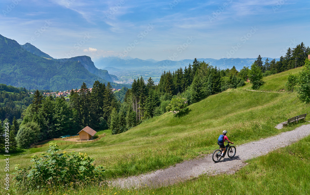 nice senior woman riding her electric mountain bike  in the Bregenzer Wald mountain range above Dornbirn and Rhein valley, in Vorarlberg, Austria