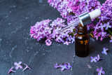 Medicinal essential oil of lilac for aromatherapy on a dark background