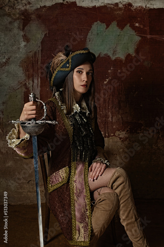 retro portrait of a musketeer girl in a hat with a sword.