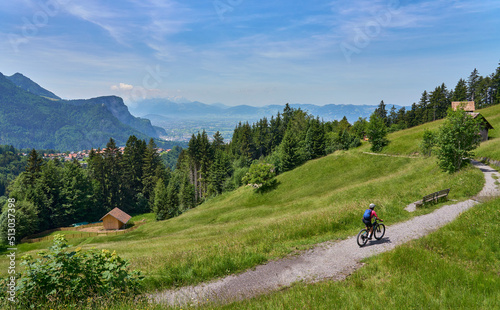 nice senior woman riding her electric mountain bike in the Bregenzer Wald mountain range above Dornbirn and Rhein valley, in Vorarlberg, Austria