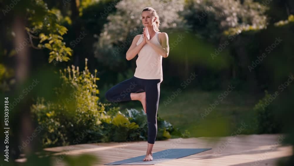 Young woman practicing yoga in the morning in her garden Young woman practicing yoga in the morning in her garden