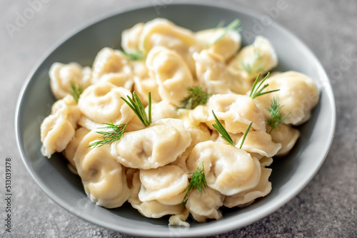 Homemade dumplings with meat - Russian dumplings. Dumplings with meat filling, ravioli on a stone background