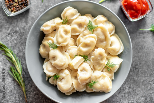 Homemade dumplings with meat - Russian dumplings. Dumplings with meat filling, ravioli on a stone background