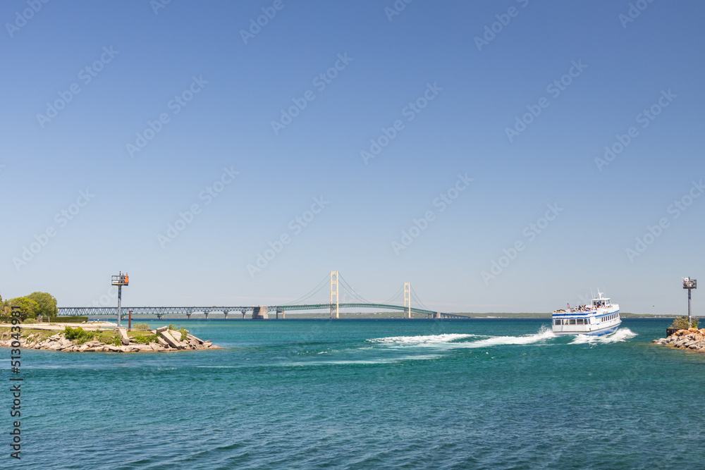 Ferry leaving the bay with Mackinac Bridge in background, Michigan, USA