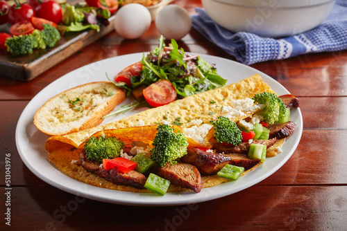 chicken omelette roll and salad served in a dish isolated on wooden background side view