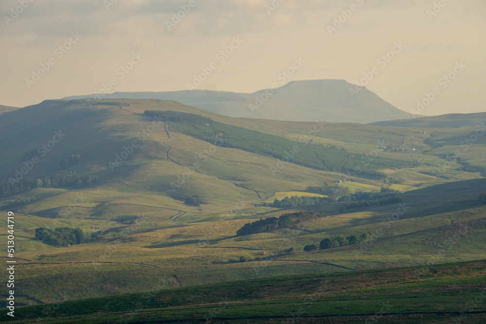 A view of Penyghent and surrounding countryside, North Yorkshire during a misty sunset