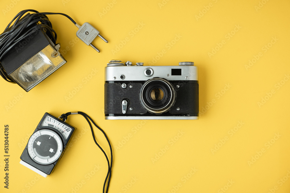 retro camera on the yellow background. Old gear for photography. Stylish background for a photo enthusiast. Flat lay