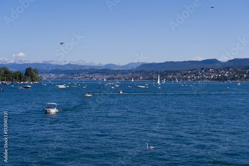 Scenic landscape with Lake Zürich, leisure boats and Swiss Alps in the background on a sunny summer day seen from City of Zürich. Photo taken June 11th, 2022, Zurich, Switzerland. © Michael Derrer Fuchs