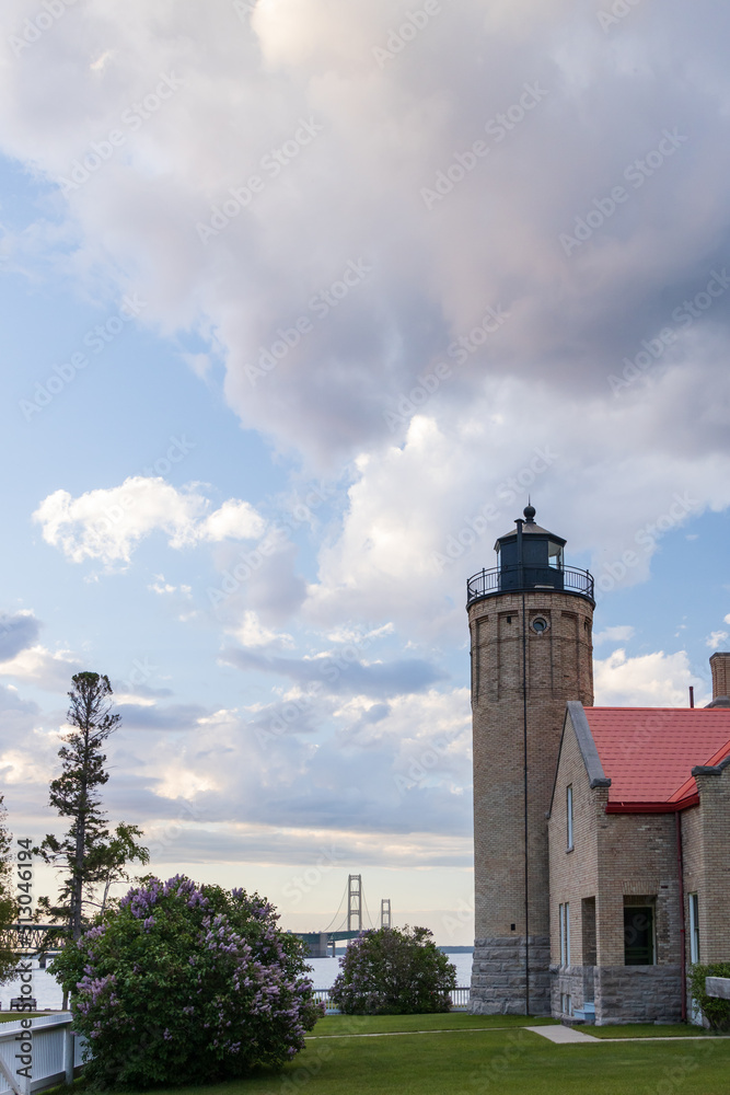 Fototapeta premium Old Mackinac Point Lighthouse at sunset with Mackinac Bridge in background, Mackinaw City, Michigan