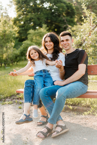 Young family dad mom and daughter enjoy a warm evening in the park © stenkovlad