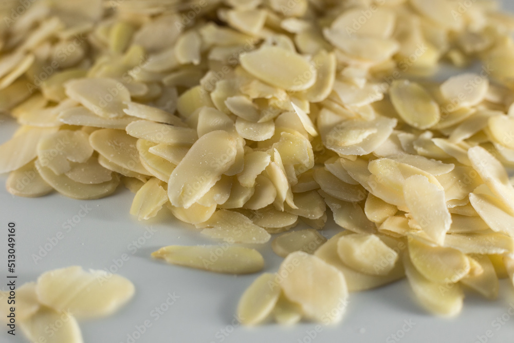 pile of healthy sliced almonds on gray background pile of healthy sliced almonds on gray background