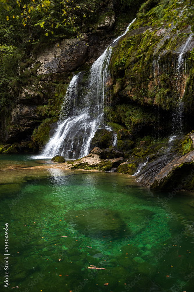 Fototapeta premium Alpine Waterfall and Emerald green lagoon on Water Stream Gljun in Bovec Slovenia