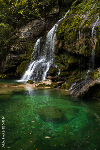 Alpine Waterfall and Emerald green lagoon on Water Stream Gljun in Bovec Slovenia