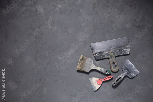 Putty knife work tool on cement floor. Tool construction renovation concept at concrete background