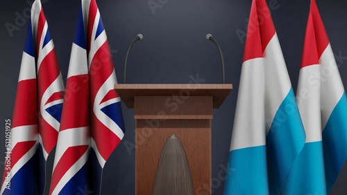 Fototapeta Naklejka Na Ścianę i Meble -  Flags of United Kingdom and Luxembourg at international meeting or negotiations press conference. Podium speaker tribune with flags and coat arms. 3d rendering