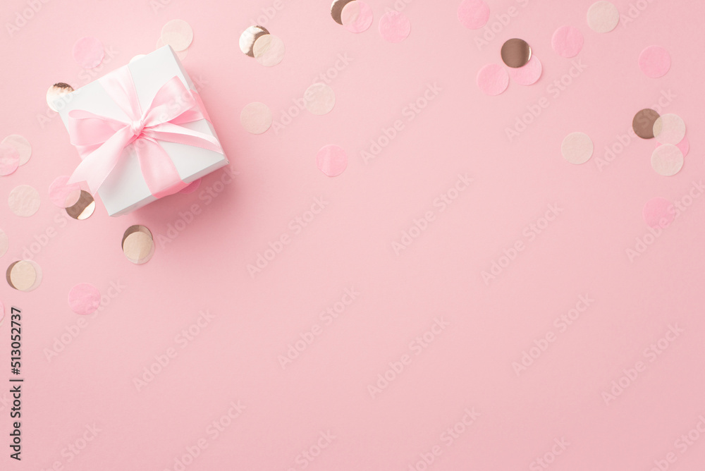 Gender party concept. Top view photo of white giftbox with ribbon bow and shiny confetti on isolated pastel pink background with empty space
