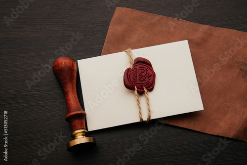 Envelope with wax seal stamp and pen on a dark table. Notary tools