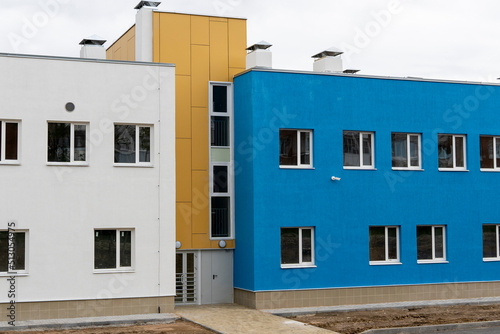 part of the facades of a new blue-yellow building with windows