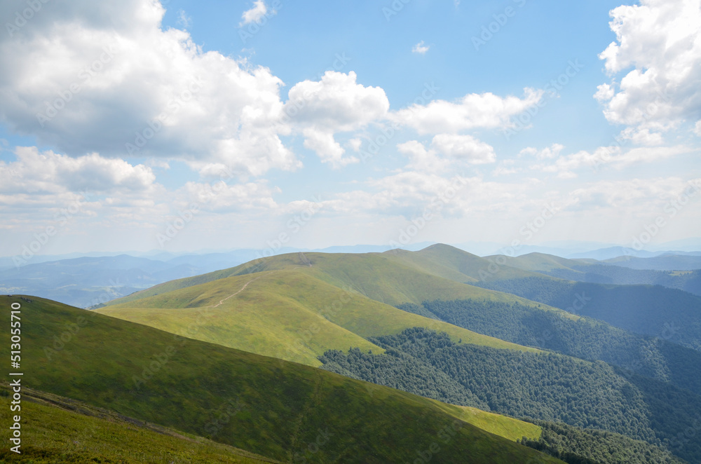 Summer landscape with green grassy slopes on the mountain ridge. Carpathian Mountains. Hiking and tourism concept