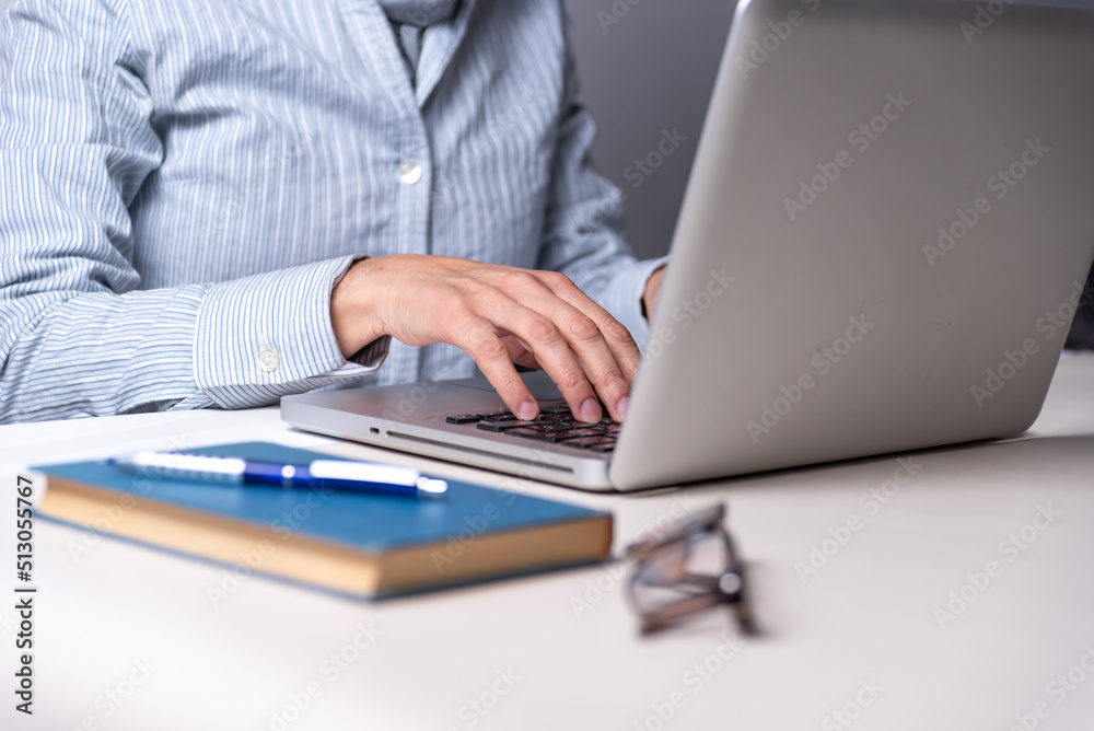 woman typing on a computer, book, eyeglasses, copy space, reading, education concept, selective focus woman typing on a computer, book, eyeglasses, copy space, reading, education concept, selective focus