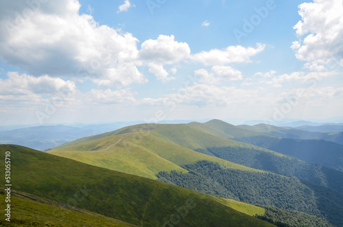 Summer landscape with green grassy slopes on the mountain ridge. Carpathian Mountains. Hiking and tourism concept