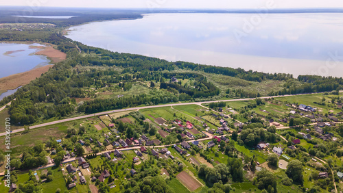 Aerial view of lake and small village. Village near the lake. Aerial view of the village and trees on the shore of lake.