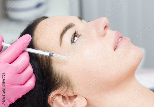 Close-up of cosmetologist makes the Rejuvenating facial injections procedure for tightening on the face skin of woman in a beauty clinic. Biorevitalization procedure