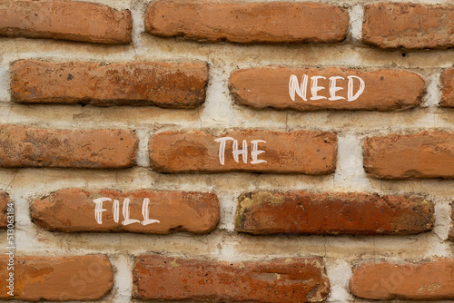 Fill the need symbol. Concept words Fill the need on red bricks on a beautiful brick wall background. Business, finacial and fill the need concept. Copy space. © Dzmitry
