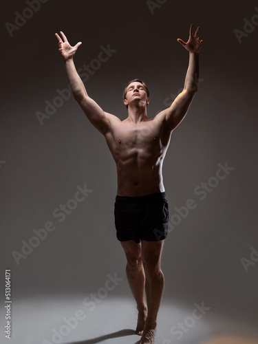 Fotografia Muscular man in an artistic pose, portrait on a gray background