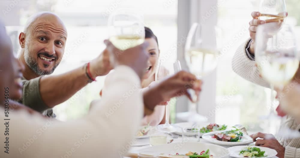 Group of friends saying cheers while lifting their wine glasses to share a toast during lunch around a table at home or a luxury hotel. Happy and diverse people eating food and celebrating friendship Group of friends saying cheers while lifting their wine glasses to share a toast during lunch around a table at home or a luxury hotel. Happy and diverse people eating food and celebrating friendship