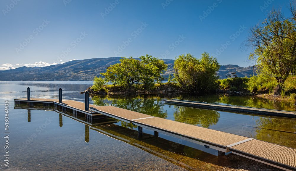 Fototapeta premium Wooden dock on a calm lake on beautiful summer morning, Okanagan Lake, Canada.