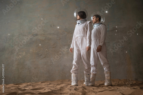 Fotografia, Obraz a man and a woman in white futuristic spacesuits explore the planet, astronauts