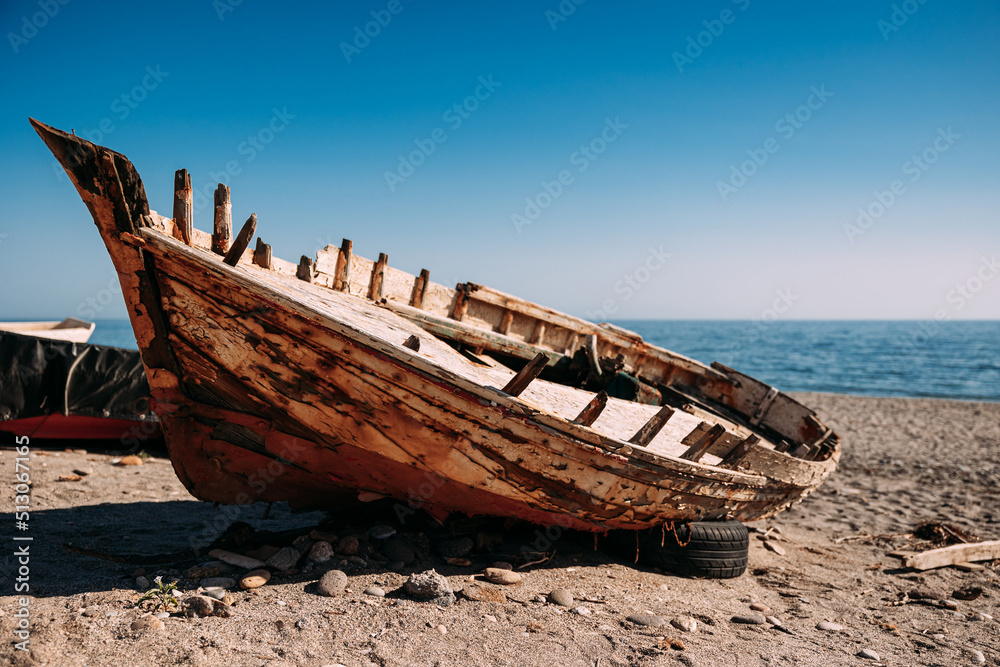 View of an old fishing boat abandoned on the shore at the beach. View of an old fishing boat abandoned on the shore at the beach.