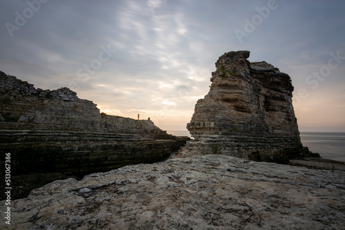 rock formations at seaside and colorful sunset with clouds