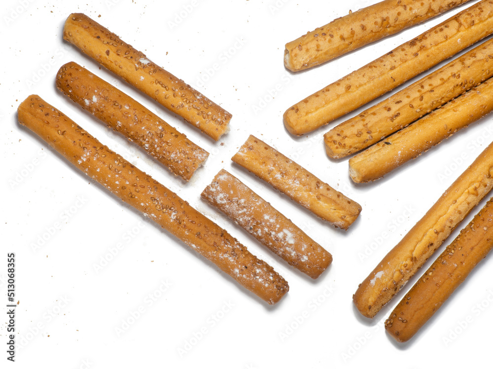 Sesame biscuits on a white background. Biscuits are elongated in the form of sticks. Bread products. Flour products. Healthy food. Sesame biscuits on a white background. Biscuits are elongated in the form of sticks. Bread products. Flour products. Healthy food.