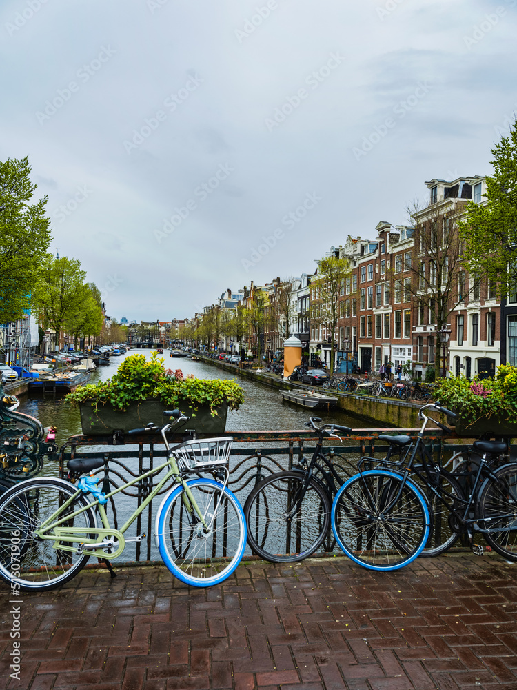Amsterdam street with cycles, canal and beautiful Dutch buildings, Netherlands