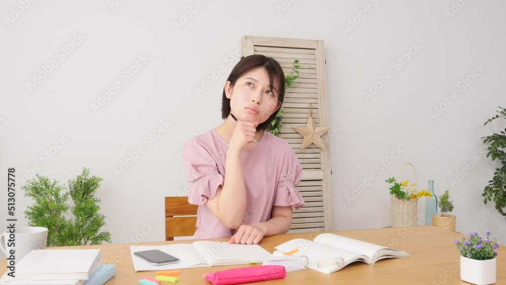 自宅で勉強中に考える女性 自宅で勉強中に考える女性