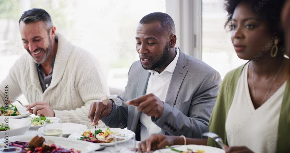 Diverse and mature group of friends eating, talking and having dinner around a table at home or at a luxury hotel restaurant. International colleagues smiling and chatting while enjoying a meal Diverse and mature group of friends eating, talking and having dinner around a table at home or at a luxury hotel restaurant. International colleagues smiling and chatting while enjoying a meal
