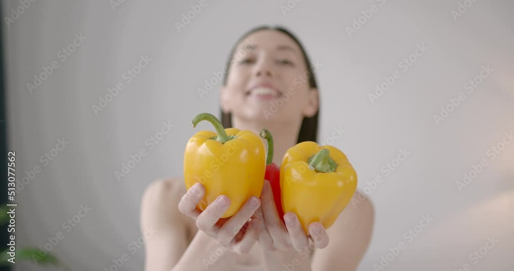 Portrait of woman holding fresh bell peppers in hands Portrait of woman holding fresh bell peppers in hands