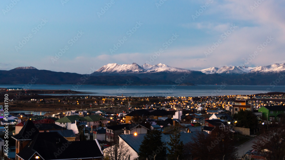 Sunset over the Beagle Channel with the buildings of Ushuaia and the snowy mountain range. Argentina
